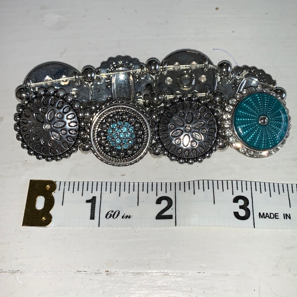 Stretch bracelet silvertone with 4 aqua blue snaps. NWOT